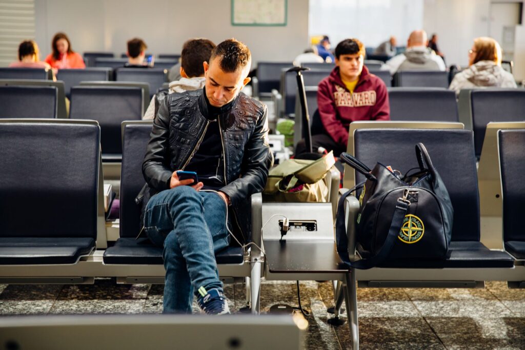 Man at an airport looking at his cellphone. 